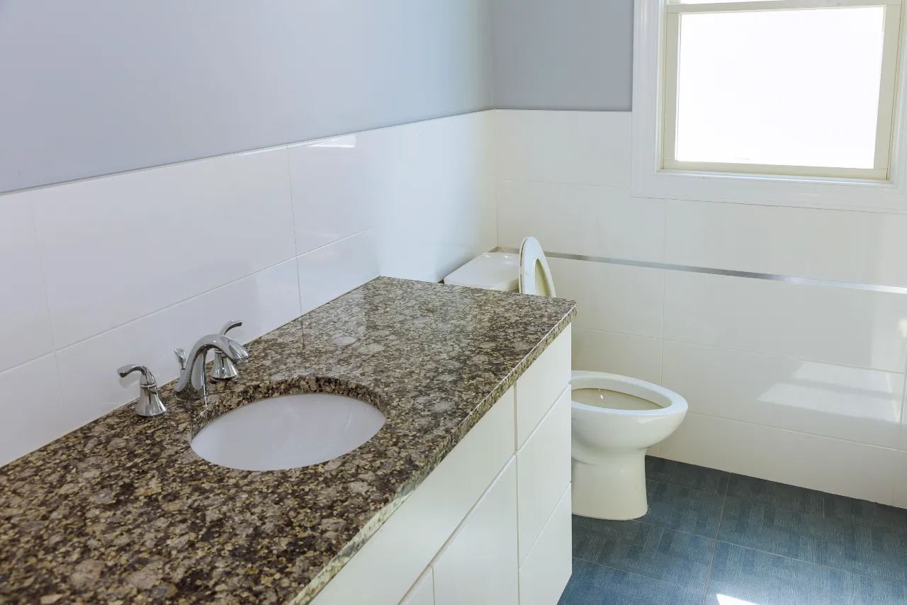 Bathroom interior with granite counter and white finishes in New Jersey