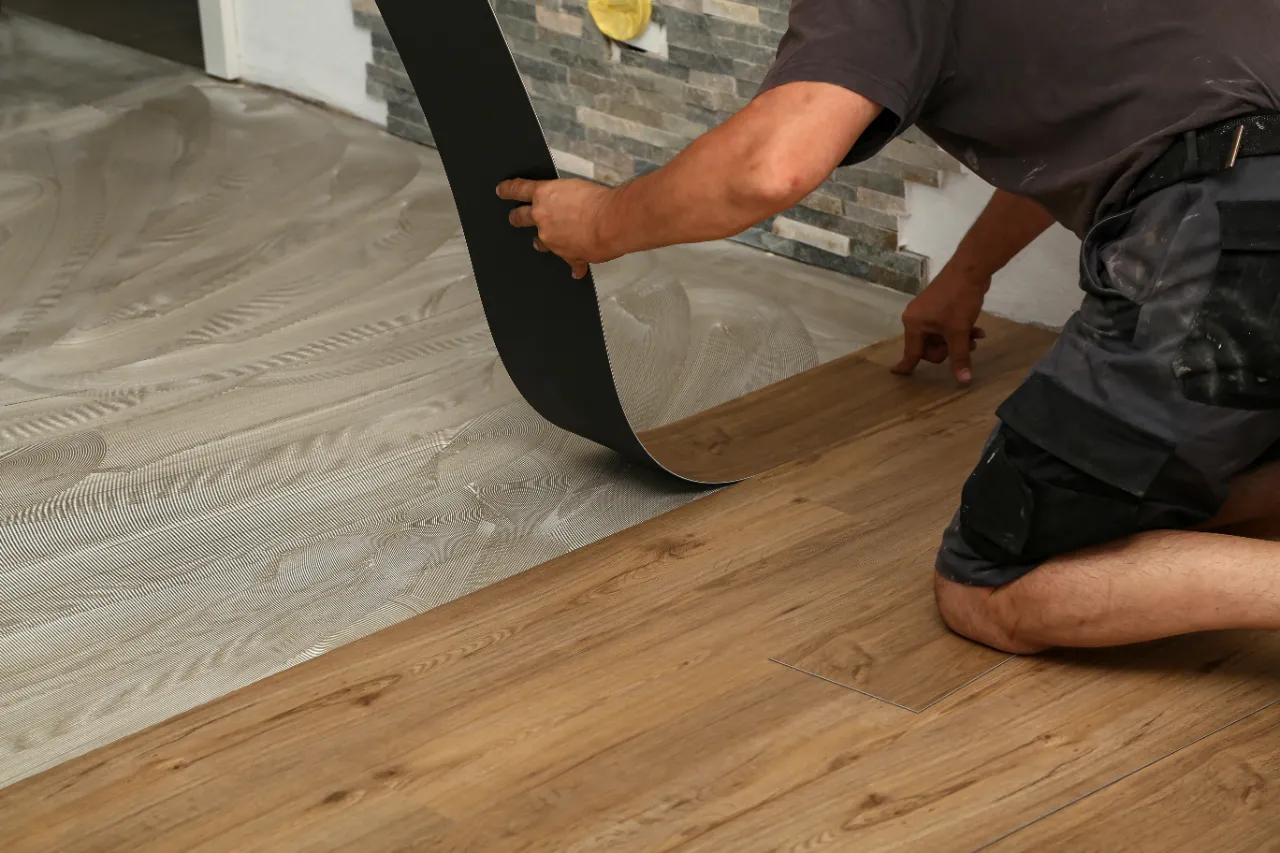 Construction worker installing vinyl flooring in New Jersey
