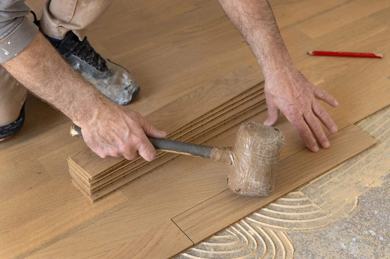 Handyman installing wooden parquet flooring in a New Jersey home