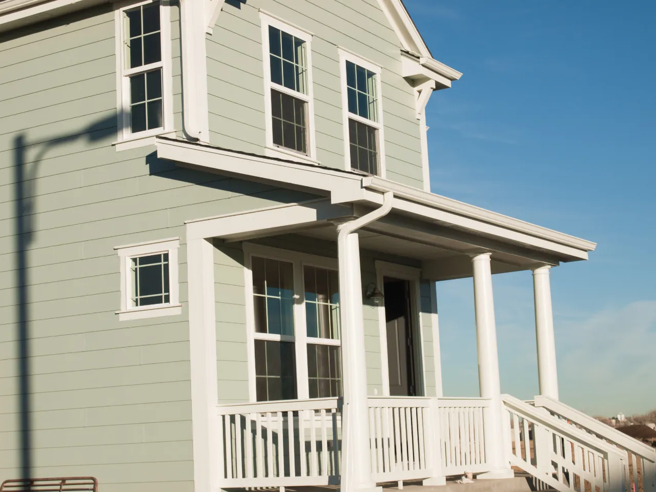 Home exterior with blue sky and white trim painted by Avelino Home Renovation in New Jersey