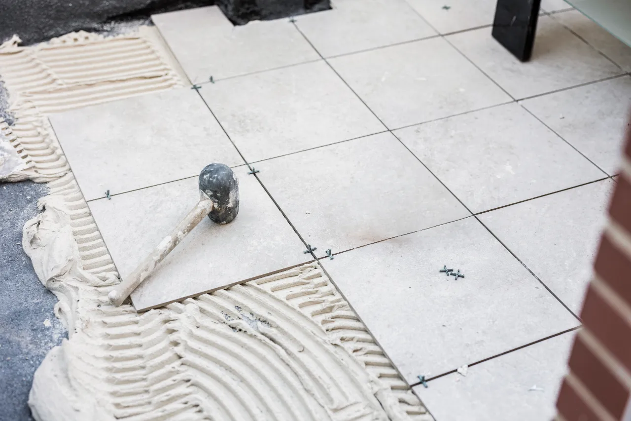 Laying ceramic tiles with cement and rubber hammer in New Jersey