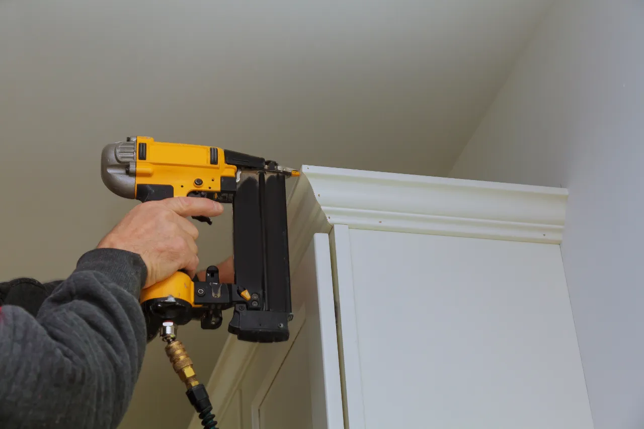 Man installing crown molding with a nail gun in New Jersey