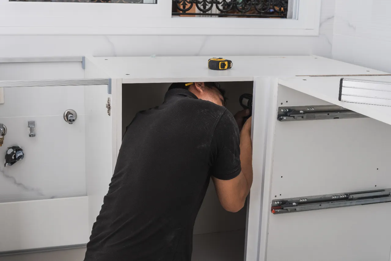 Contractor installing white cabinets in a modern New Jersey kitchen