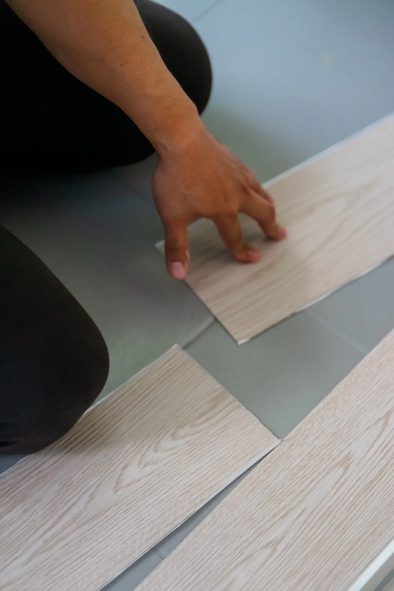 Person installing wood look vinyl flooring in a New Jersey home