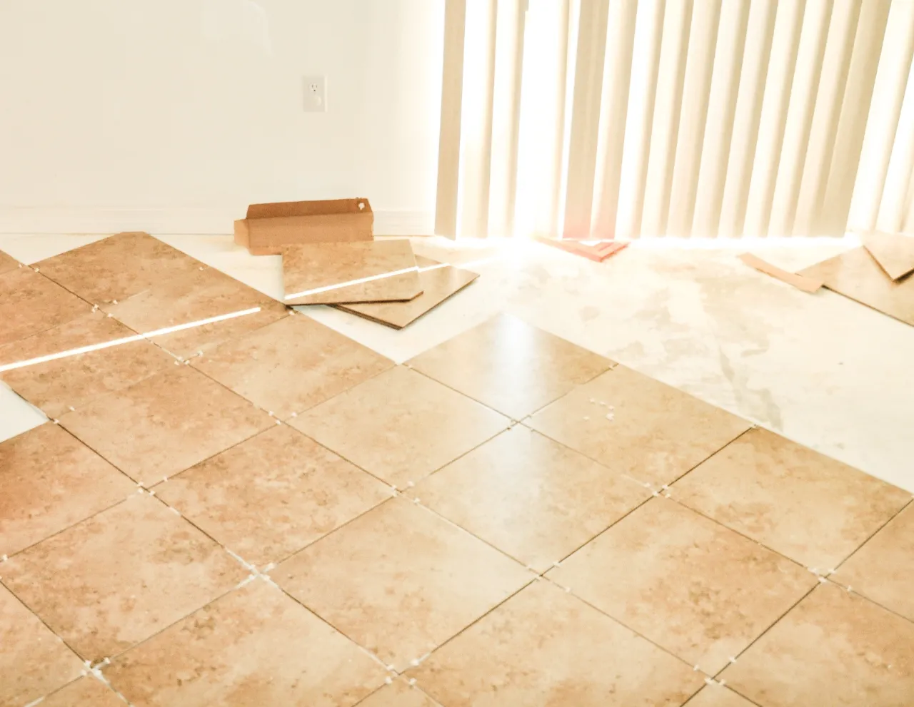 Tan tiles being installed in an empty room in New Jersey