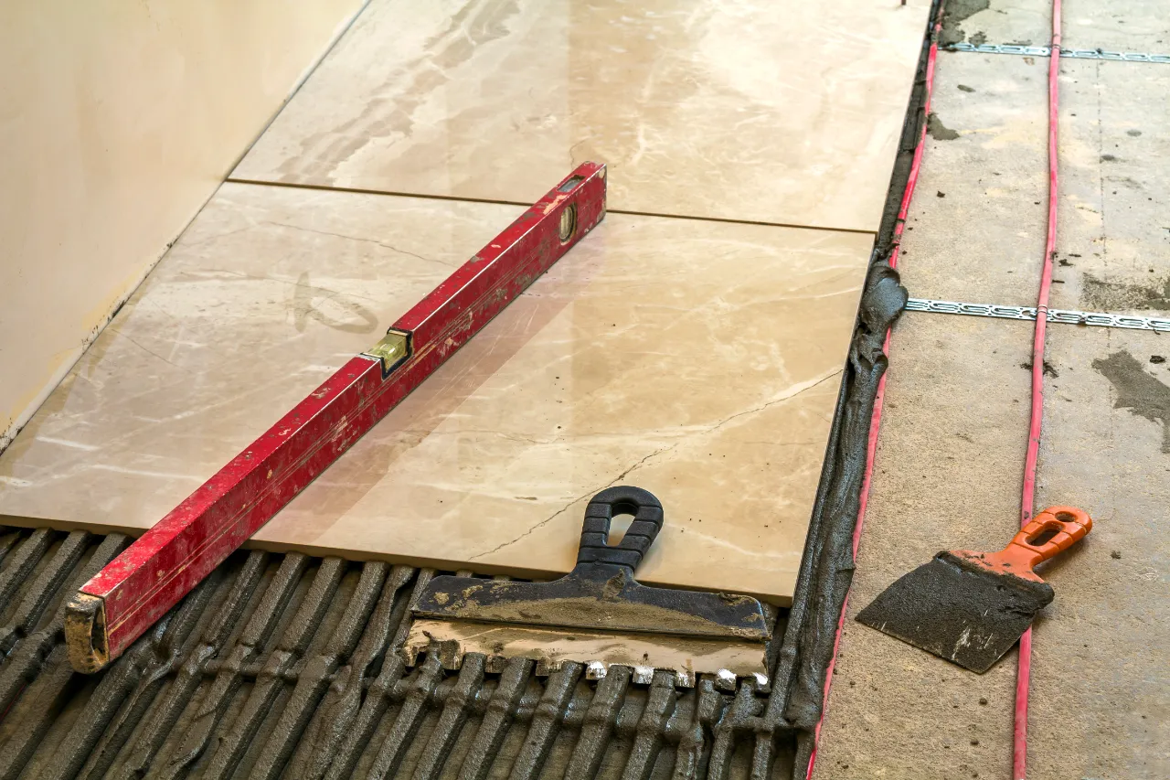 Tile installation renovation with level and trowel in New Jersey